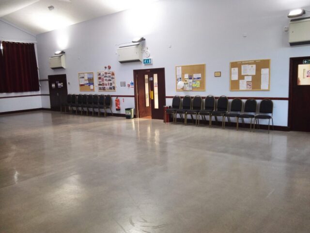 Left side of hall facing entrance doors