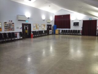 Centre of hall facing main doors and fire exit